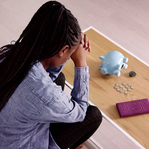 Short on Cash image of lady praying and empty piggy bank
